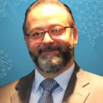 Smiling headshot of a man with aqua background