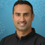 Headshot of a man in black shirt smiling