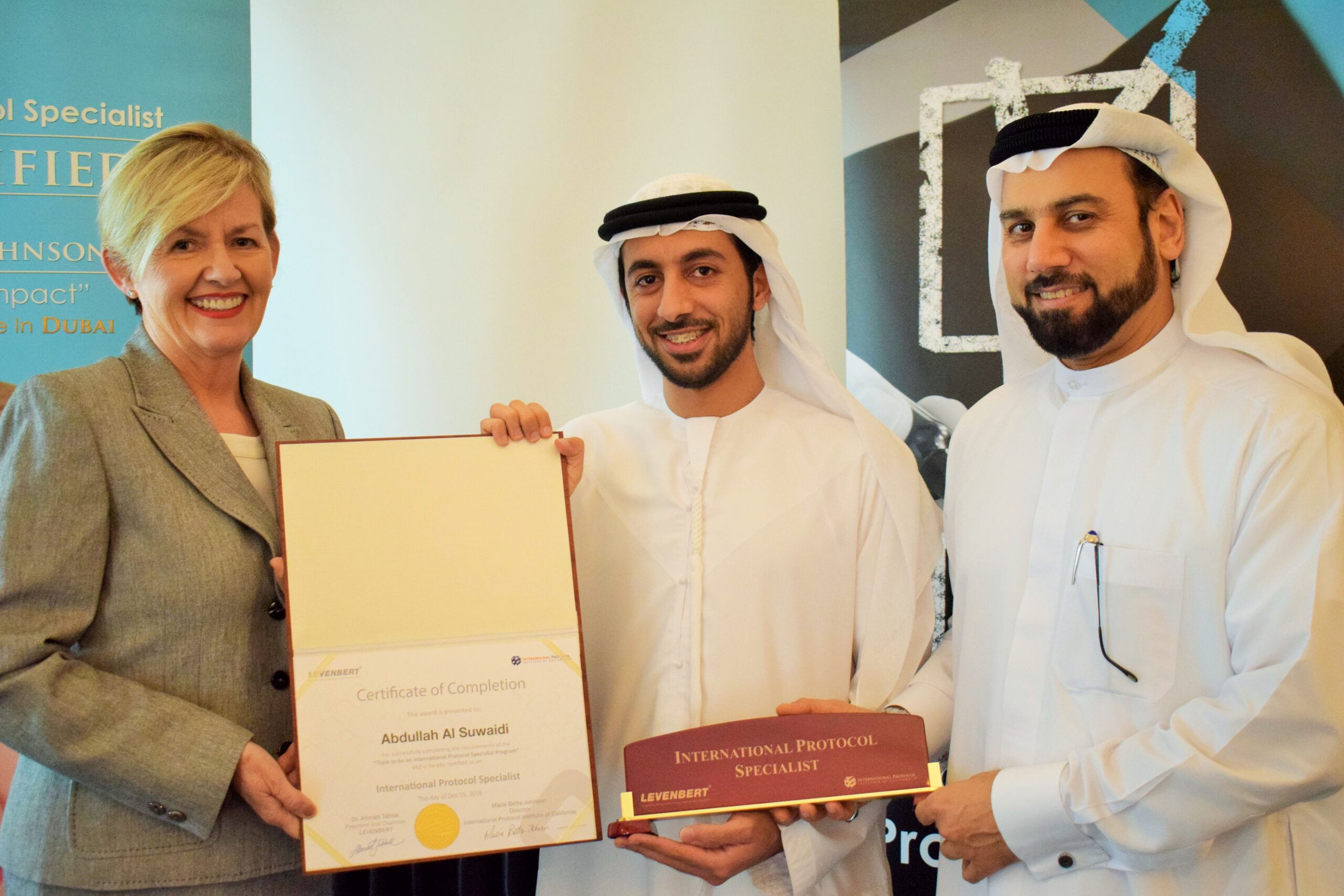 A woman presenting a certificate to a man