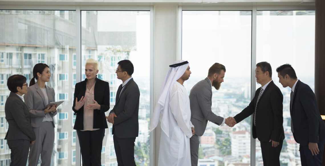 Group of people handshaking and others talking