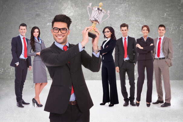 A man showing the trophy with other people standing behind