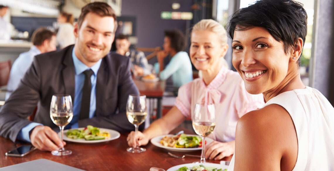 Group of people smiling and having food