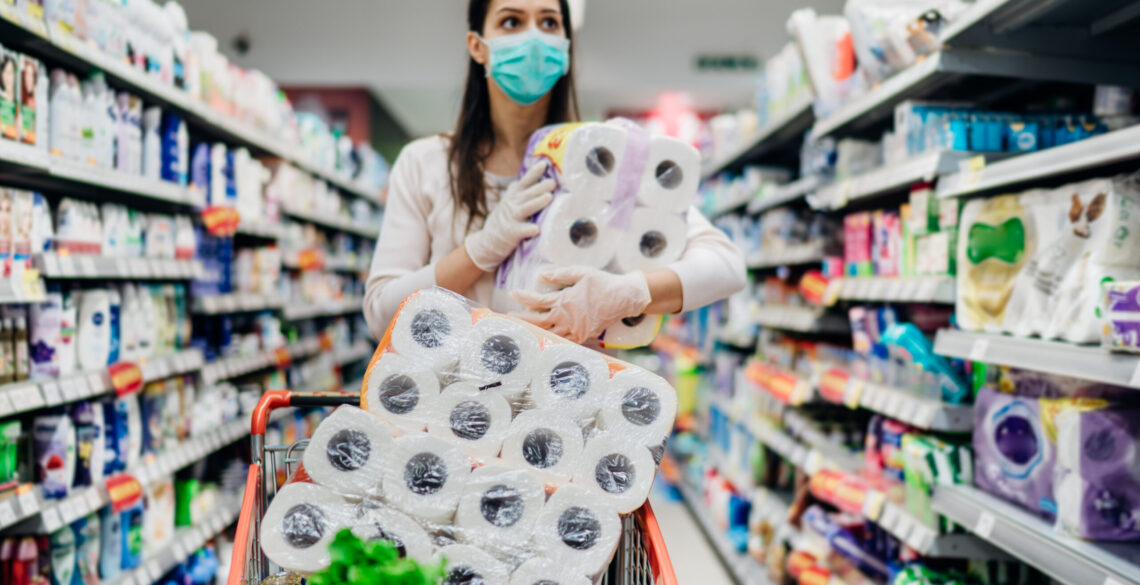 A woman holding toilette paper rolls