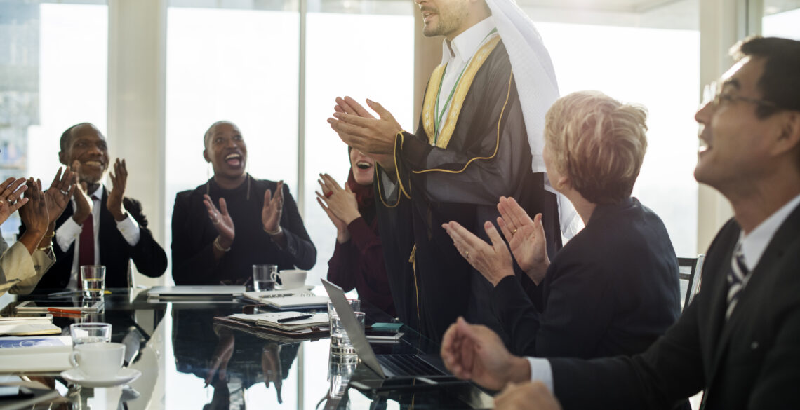 Group of people clapping for a man standing